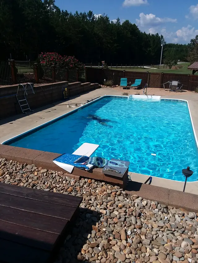 Portrait view of a rectangular pool with its equipment and a paved deck